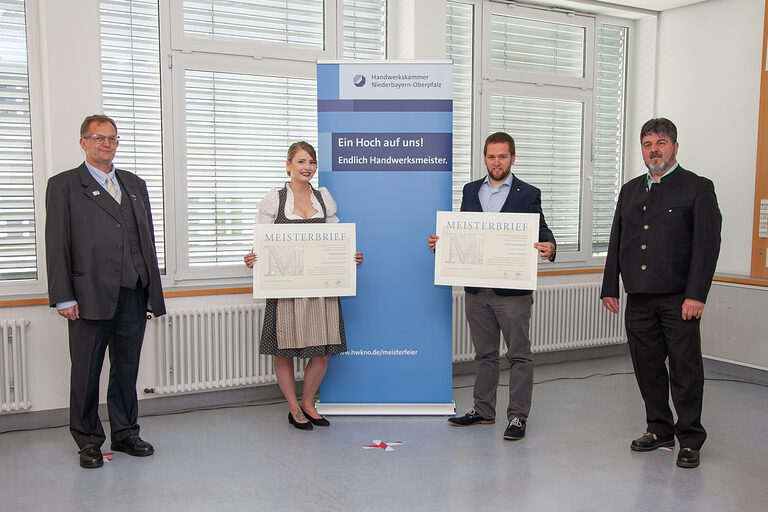 Bildungszentrumsleiter Josef Sailer (links) und Kursleiter Georg Maier (rechts) überreichten Glasveredlerin Karin Raith und Glaser Simon Derkacz den begehrten Meisterbrief. 