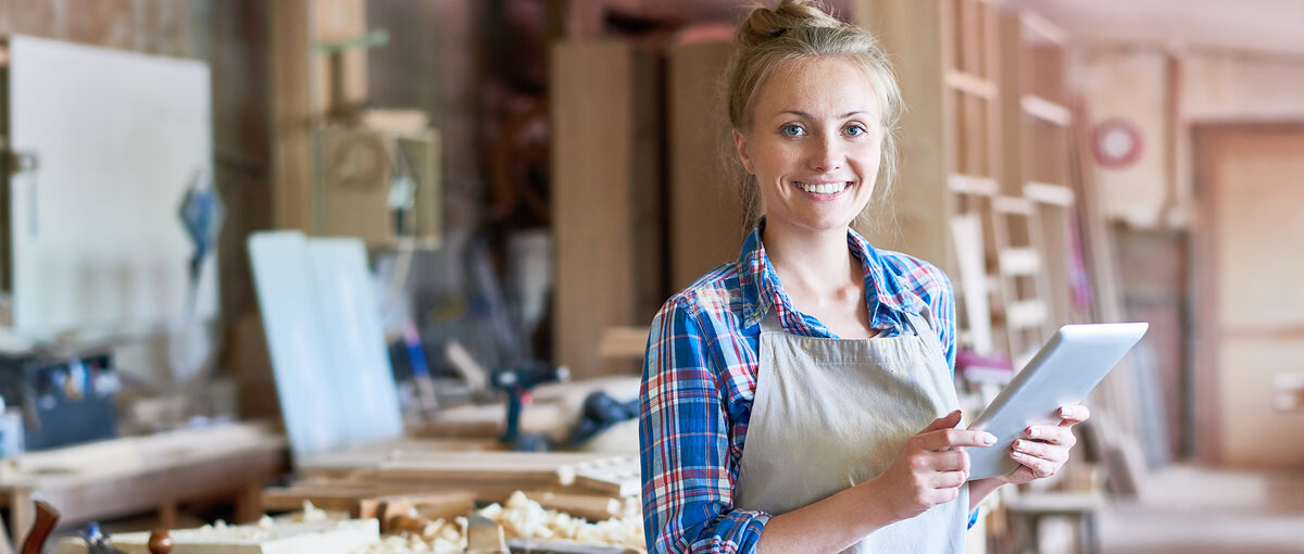 Portrait of happy young woman looking at camera using digital tablet in modern woodworking shop, copy space Schlagwort(e): small, business, traditional, craft, wood, wooden, woodwork, carpenter, carpenting, carpentry, joiner, joinery, manufactory, manufacturing, occupation, modern, workshop, work, shop, young, woman, female, using, digital, tablet, technology, connectivity, looking, camera, smiling, happy, manager, small, business, traditional, craft, wood, wooden, woodwork, carpenter, carpenting, carpentry, joiner, joinery, manufactory, manufacturing, occupation, modern, workshop, work, shop, young, woman, female, using, digital, tablet, technology, connectivity, looking, camera, smiling, happy, manager