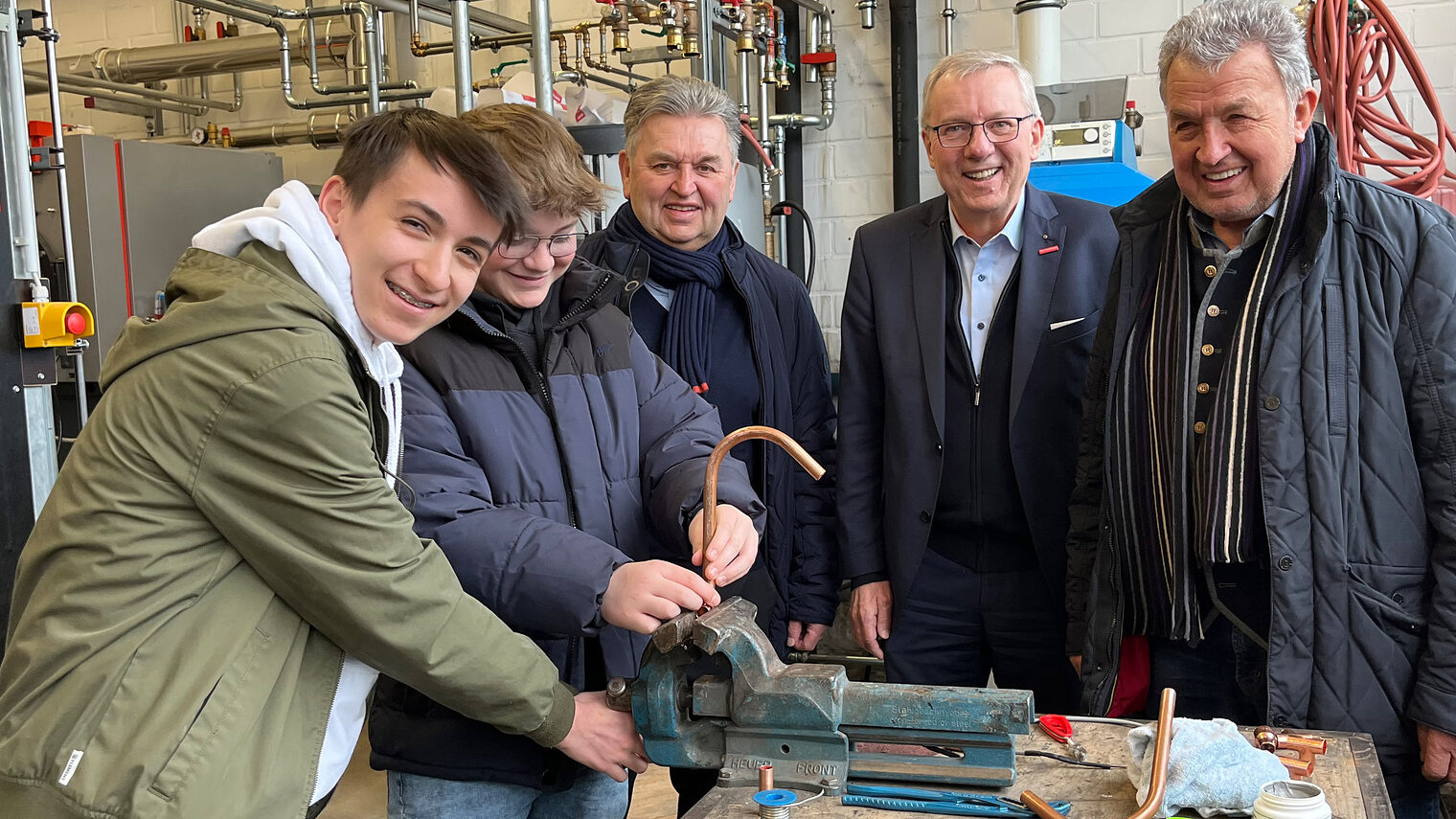 Gute Stimmung in der Lehrwerkstatt: Karl Laußer, HWK-Hauptgeschäftsführer Jürgen Kilger, Heribert Laußer und die beiden Achtklässler Johannes Six und Marcel Huschka (v.re.) fachsimpeln an der Werkbank.