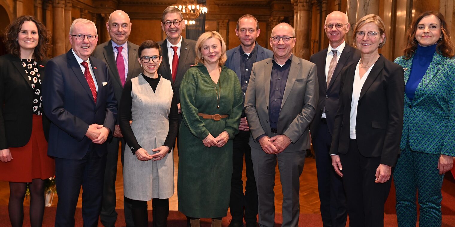 Männer und Frauen aus Handwerk und Wirtschaft stehen für ein Gruppenfoto zusammen.
