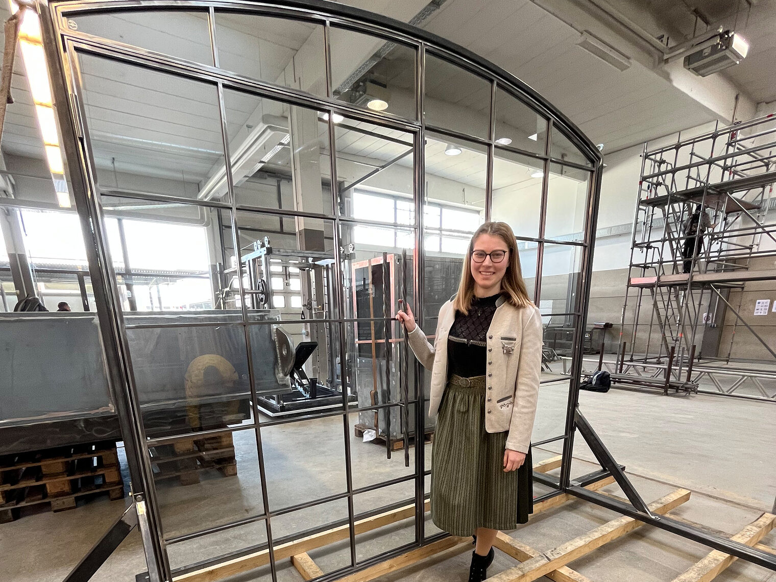 Metallbaumeisterin Alina Schäffler steht vor ihrem Meisterstück, einer Tür im Loft-Design.