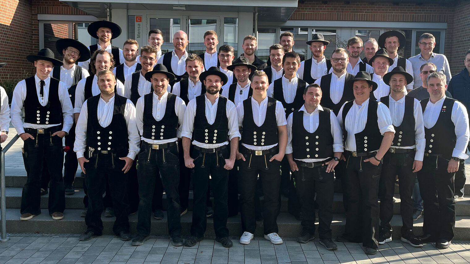 28 frisch gebackene Zimmerermeister in ihrer Zimmermannskluft mit Kursleiter Georg Weiherer und den Prüfungsausschussmitgliedern. 