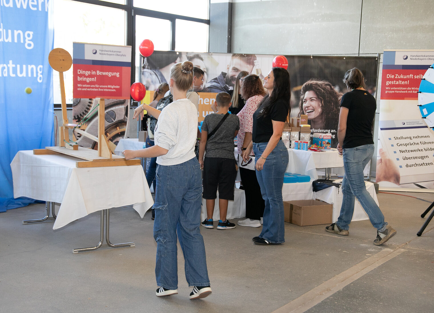 Jugendliche probieren sich an der Wurfmaschine beim Stand der Imagekampagne aus. 