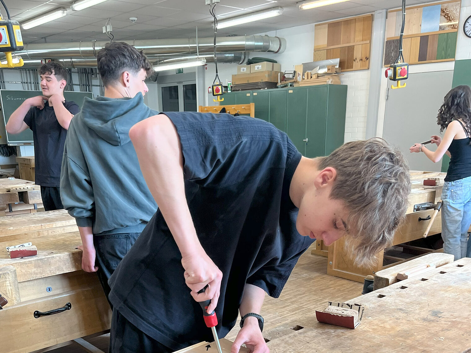 Bei der Anfertigung der Topfuntersetzer in der Schreinerwerkstatt ist Präzision gefragt. Auf dem Bild sieht man einen konzentrierten Schüler. 