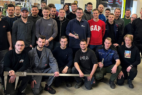 Ein Gruppenbild mit den Meisterprüfungsabsolventen im Feinwerkmechanikerhandwerk in der Werkstatt mit ihrem Kursleiter Wolfgang Meyer.