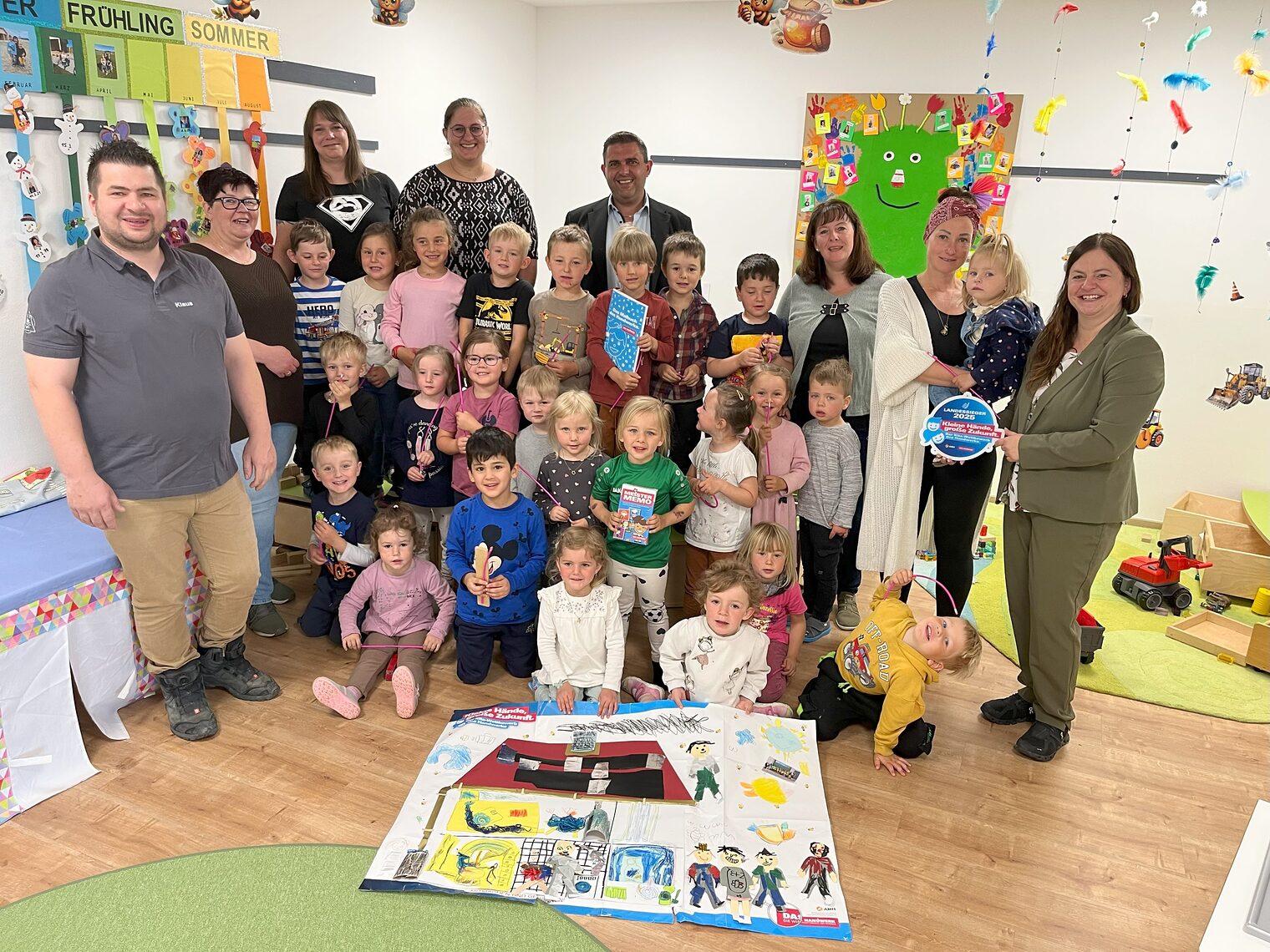 Die Kinder der Kindertagesstätte Don Bosco freuen sich mit ihren Erzieherinnen über den Landessieg und zeigen stolz ihr Plakat.
