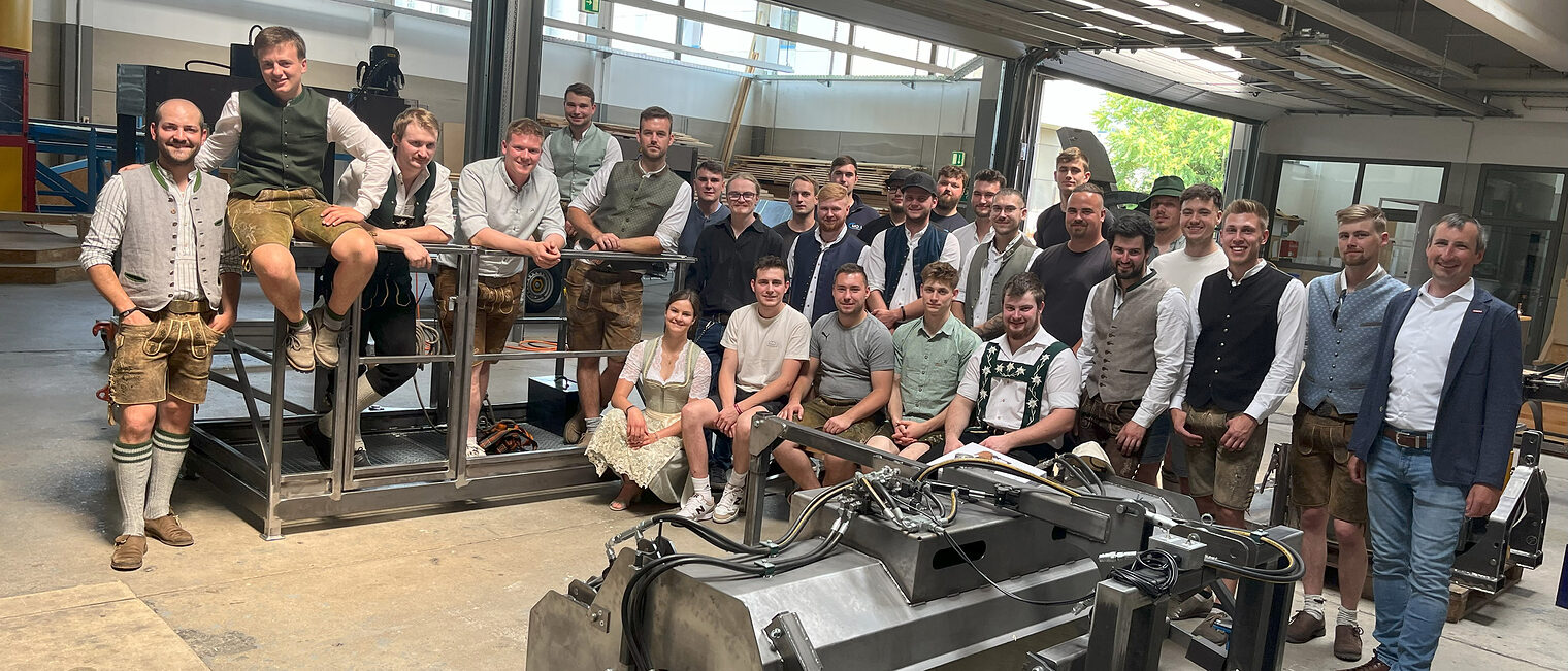 Die Absolventen des diesjährigen Meisterkurses Metallbau stehen mit Kursleiter Peter Fitterer aufgereiht in der Metallhalle in Regensburg.