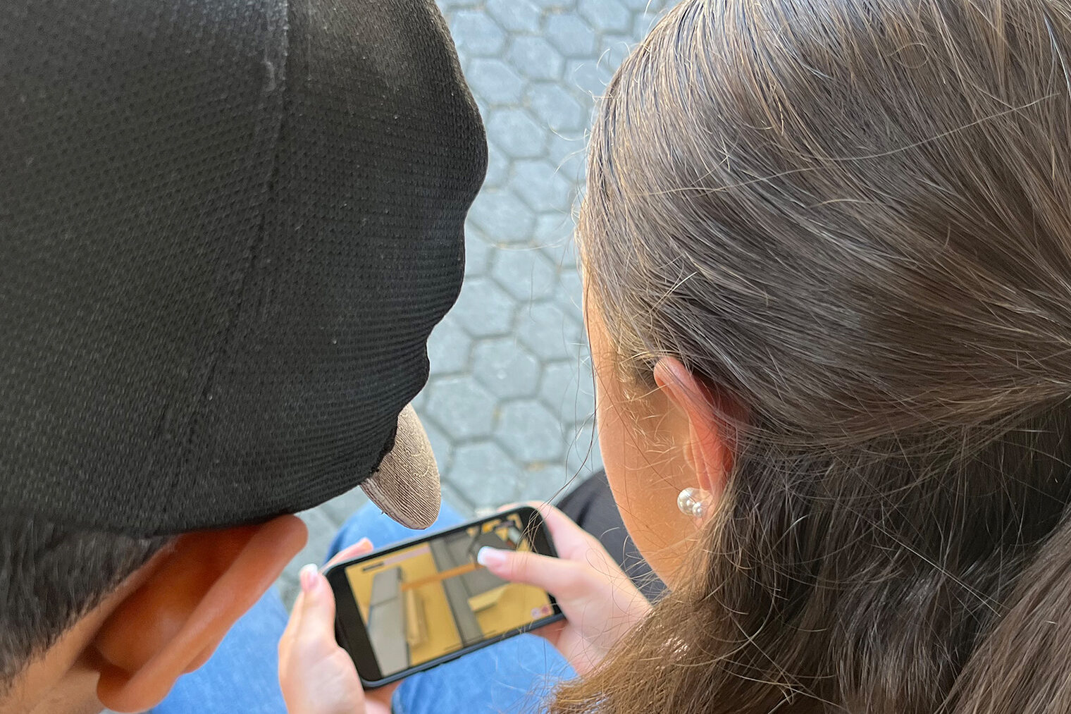 Zwei Jugendliche spielen das virtuelle Praktikum auf einem Smartphone. 