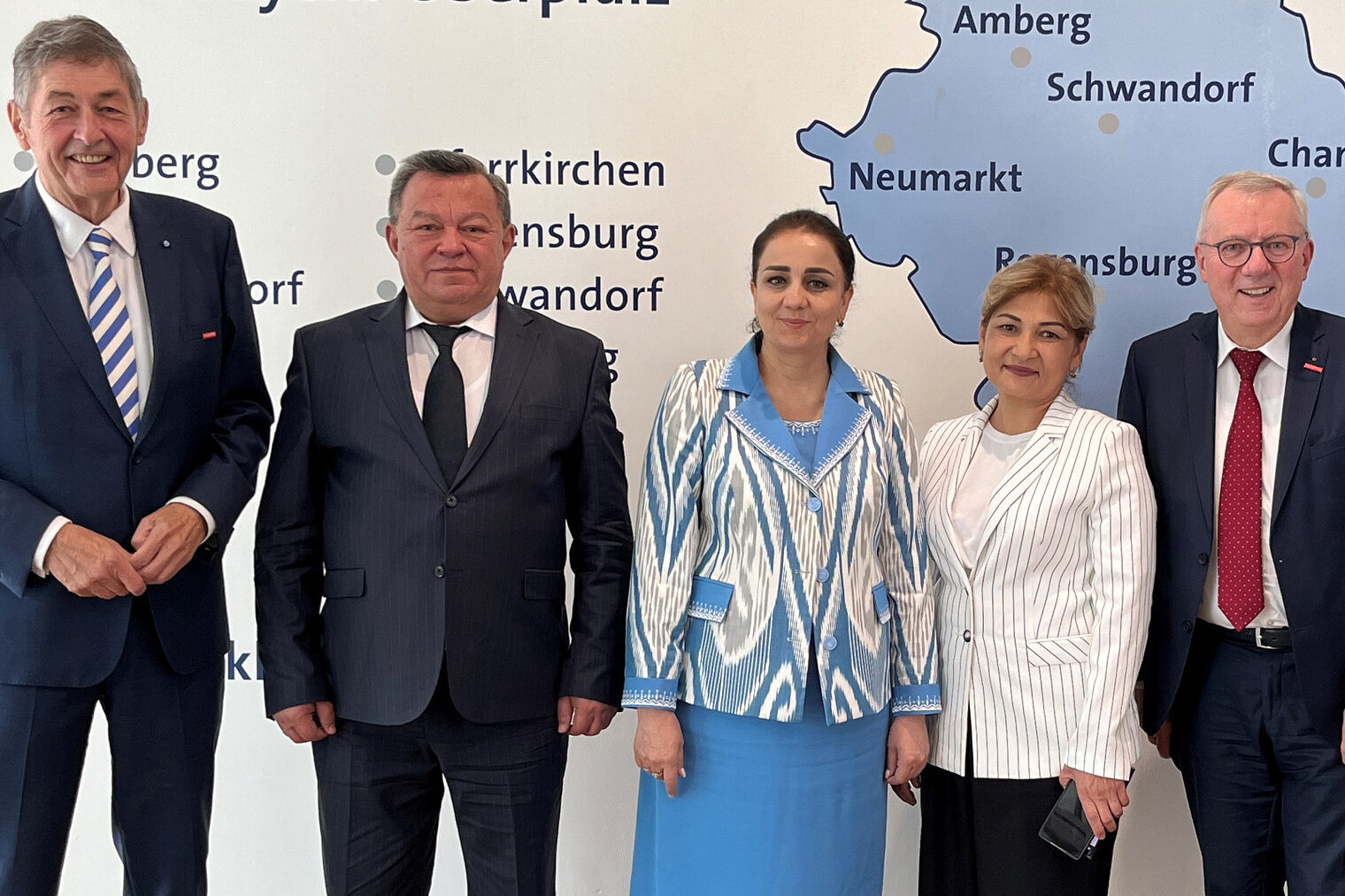 Sechs Personen, darunter Vertreter der Handwerkskammer, stehen in formeller Kleidung vor einer Karte der Region Niederbayern-Oberpfalz.