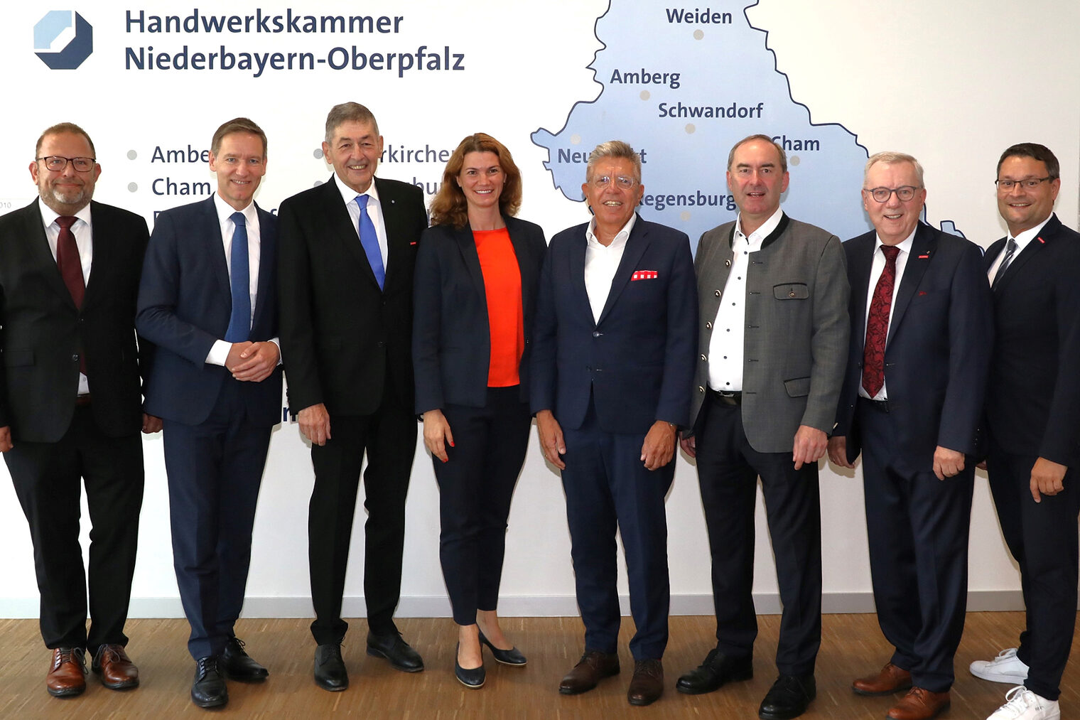 Die Ehrengäste der Festveranstaltung stellen sich vor der Wand mit der Karte von Niederbayern und Oberpfalz für das Foto auf. 
