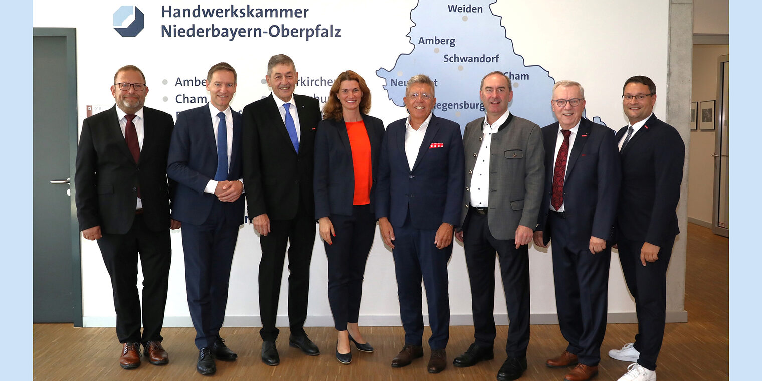 Die Ehrengäste der Festveranstaltung stellen sich vor der Wand mit der Karte von Niederbayern und Oberpfalz für das Foto auf. 