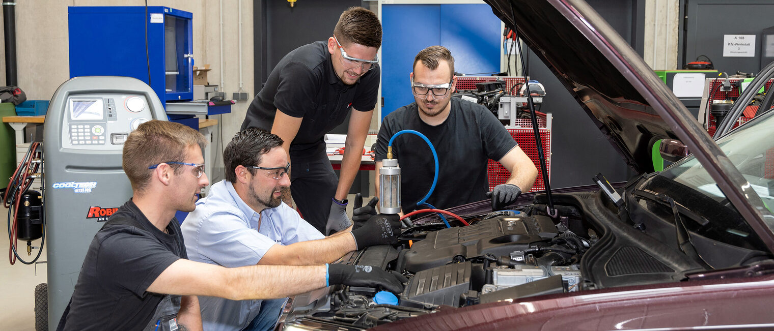 Einer der beliebtesten Ausbildungsberufe im ostbayerischen Handwerk ist in diesem Jahr der Kfz-Mechatroniker. Drei Auszubildende im Kfz-Mechatronikerhandwerk untersuchen mit ihrem Ausbilder ein Auto in der KFZ-Werkstatt.