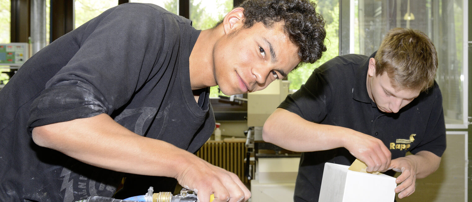 Ein junger Mann benutzt ein Schleifgerät.