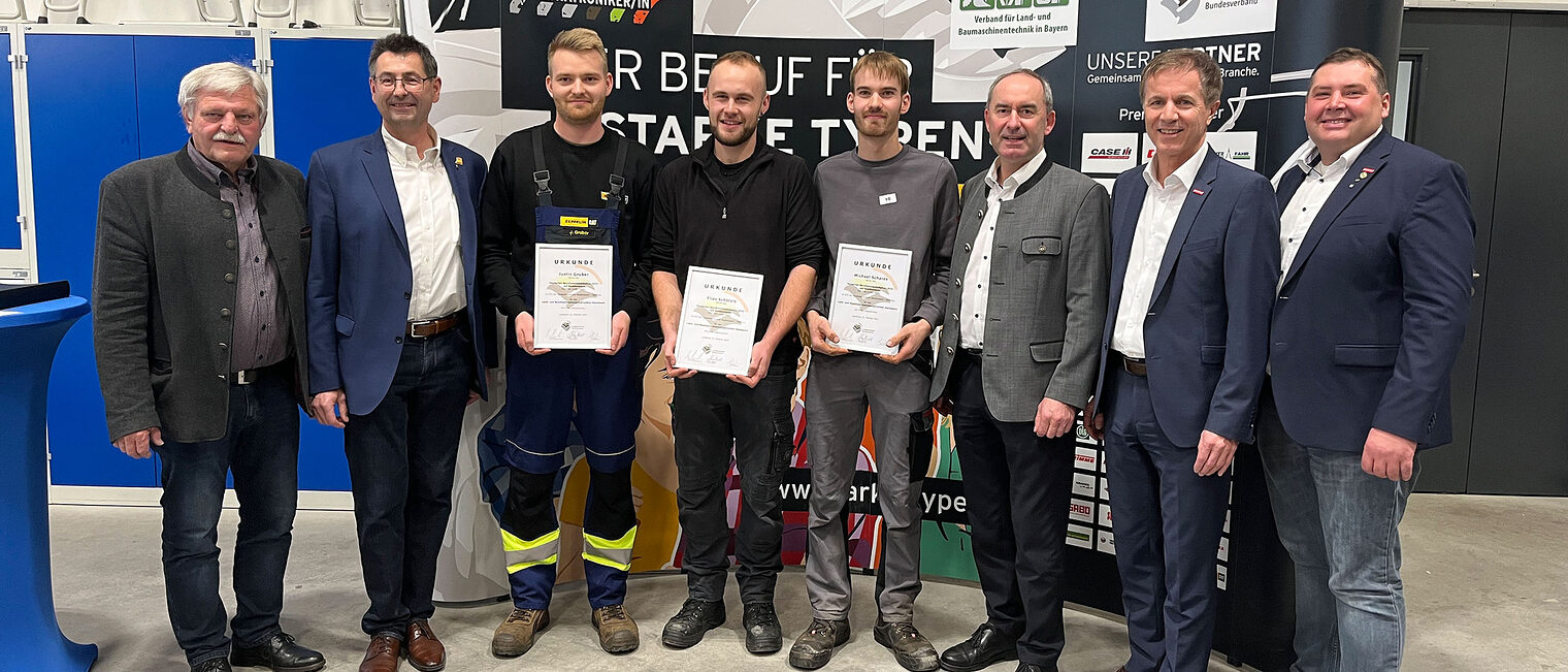 Die drei Bundessieger halten Stolz ihre Urkunden in die Kamera. Auf dem Foto sind sie mit Ehrengästen und Veranstaltern zu sehen.
