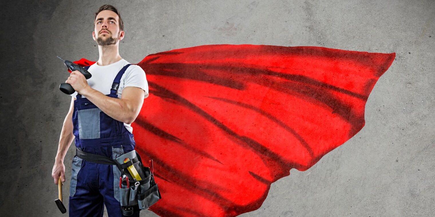 Ein Handwerker steht stolz mit seinen Werkzeugen, einem Hammer und einer Bohrmaschine, im Bild. Er trägt einen Umhang, wie ein Superheld.