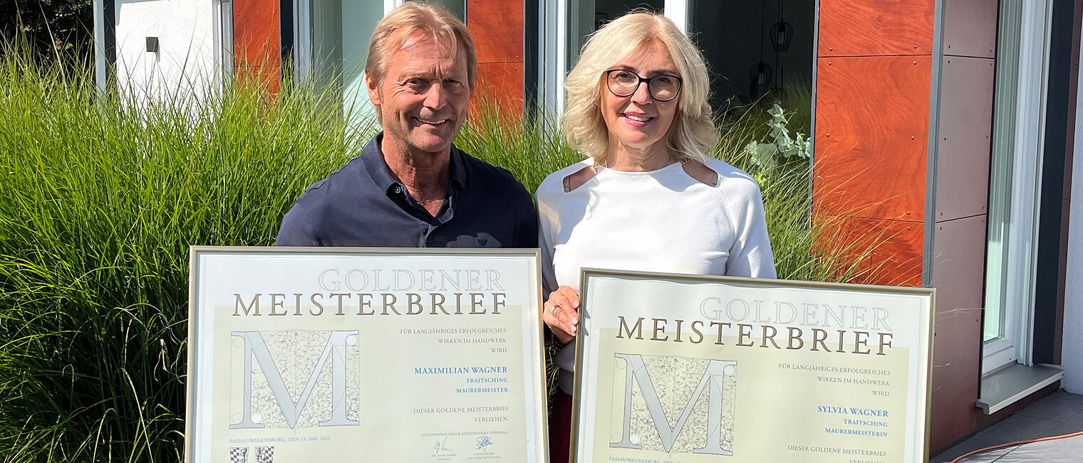 Das Ehepaar Sylvia und Maximilian Wagner lernten sich in der Meisterschule kennen. Sie halten ihre Goldenen Meisterbriefe in die Kamera. 