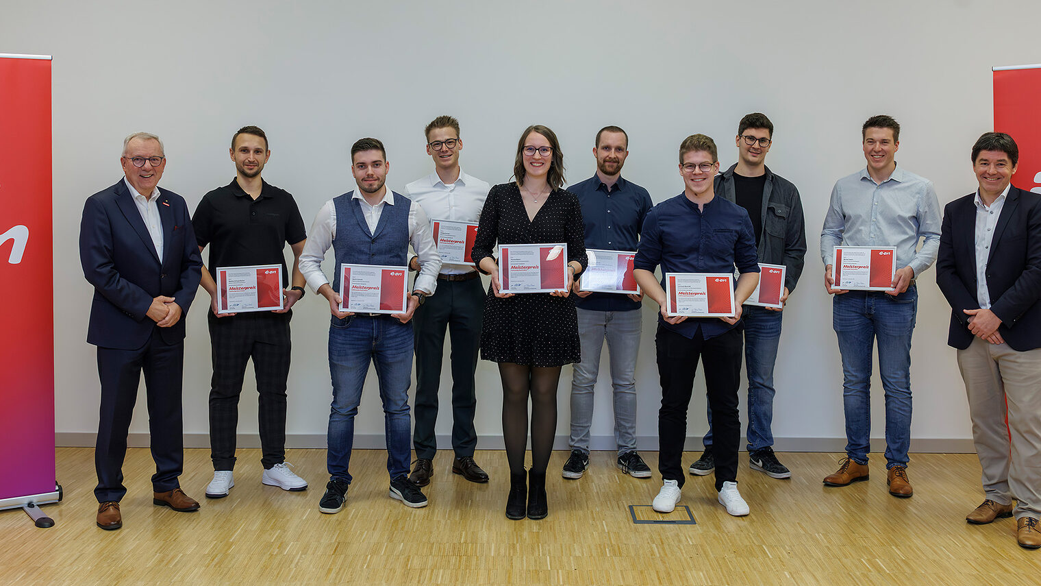 Die Preisträger des EON-Meisterpreises mit Urkunden und HWK-Hauptgeschäftsführer Jürgen Kilger in der Mitte zweier EON-Banner.