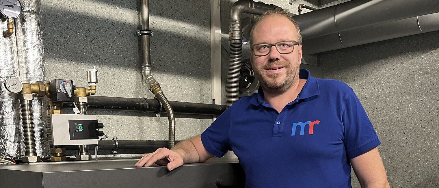 Michael Rädle neben dem „Herzstück“ seines Betriebsgeländes: hier wird Holz in nachhaltige Energie für das gesamte Gewerbegebiet umgewandelt. 