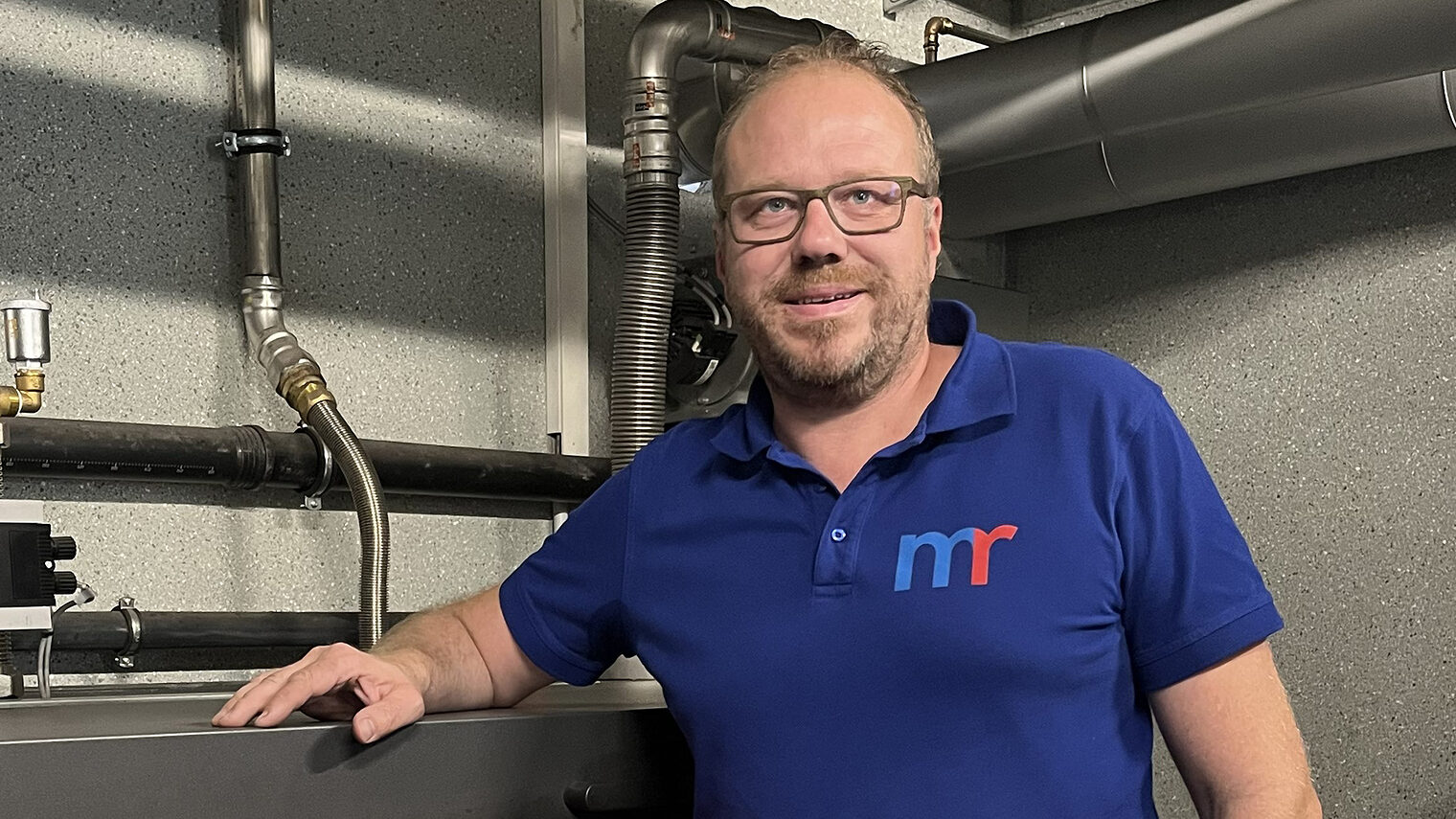 Michael Rädle neben dem „Herzstück“ seines Betriebsgeländes: hier wird Holz in nachhaltige Energie für das gesamte Gewerbegebiet umgewandelt. 