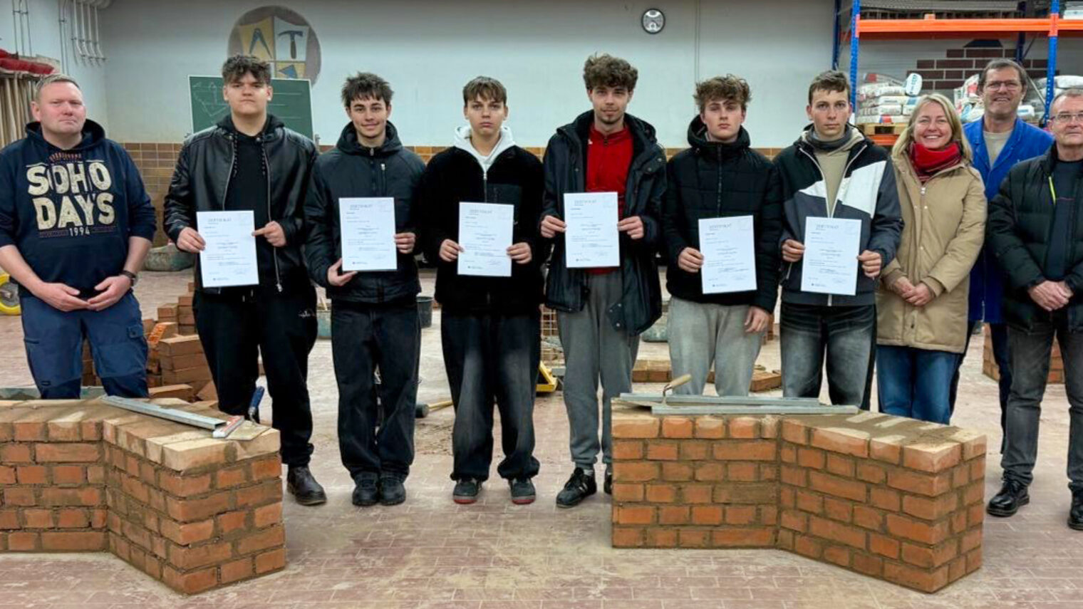 Tschechische Teilnehmer des Schüleraustauschs mit Lehrern, dem Direktor der Baufachschule und HWK-Ausbilder in der Bauhalle.