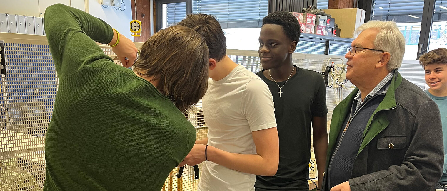 HWK-Vizepräsident Gerhard Ulm mit den Schülern des Gymnasiums Parsberg in der Elektrowerkstatt. Hier mussten die Nachwuchshandwerker einen einfachen Stromkreis verkabeln. 