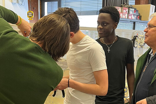 HWK-Vizepräsident Gerhard Ulm mit den Schülern des Gymnasiums Parsberg in der Elektrowerkstatt. Hier mussten die Nachwuchshandwerker einen einfachen Stromkreis verkabeln. 