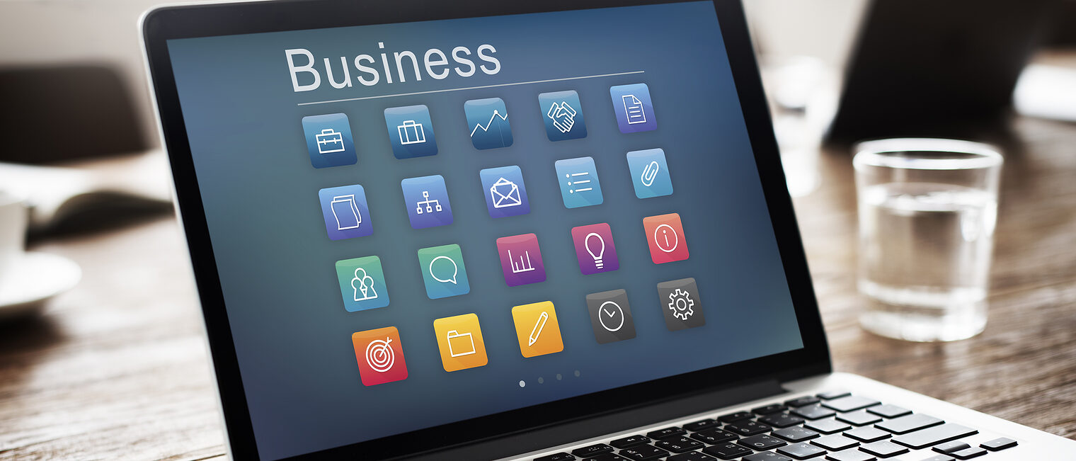 Ein Laptop steht auf einem Tisch. Darauf ist das Wort Business zu lesen.