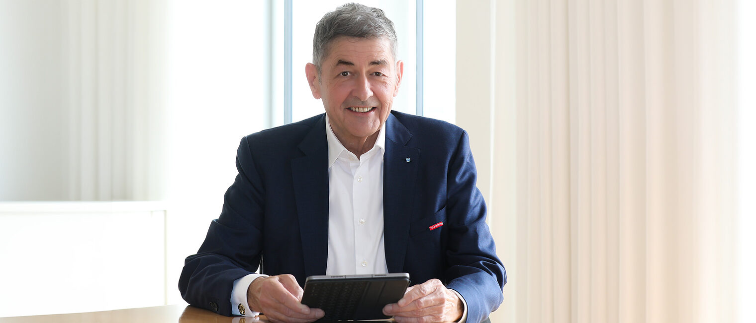 Im Gespräch mit Präsident Dr. Georg Haber. Er sitzt in seinem Büro und hält ein Tablet in der Hand.