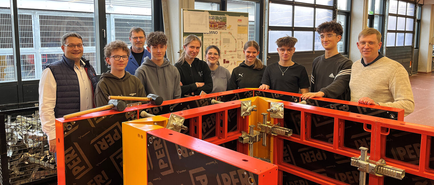 Die Schüler des Augustinus-Gymnasiums mit den Vertretern der Handwerkskammer stehen vor ihrer aufgebauten Schalung.