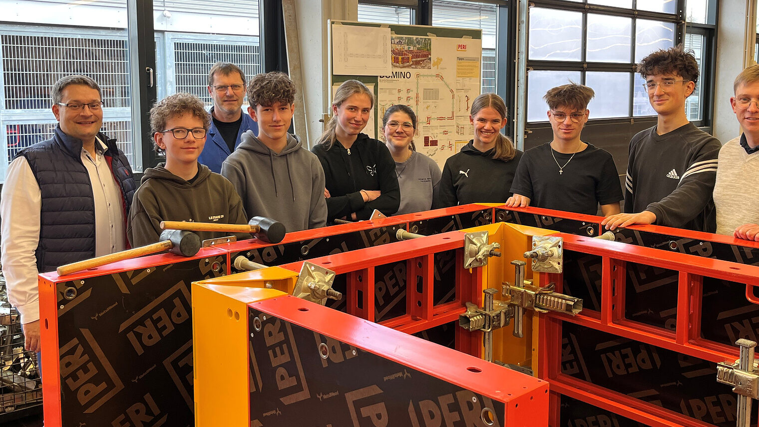 Die Schüler des Augustinus-Gymnasiums mit den Vertretern der Handwerkskammer stehen vor ihrer aufgebauten Schalung.