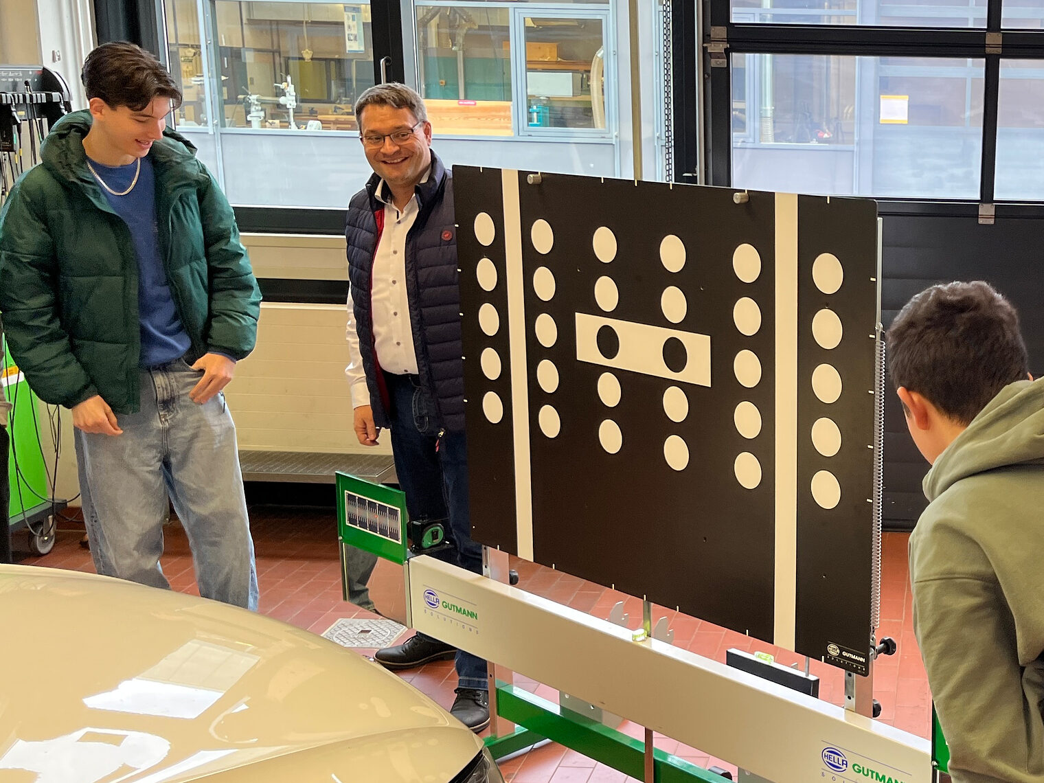 Mit ruhigen Händen rekalibrieren die Schüler eine Scheiben-Kamera. Geschäftsführer Alexander Stahl sieht die Begeisterung.