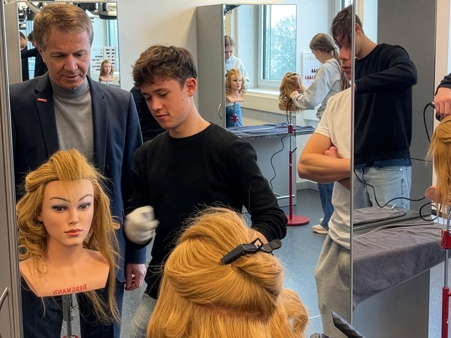 Hans Schmidt mit einem Schüler in der Friseurwerkstatt.