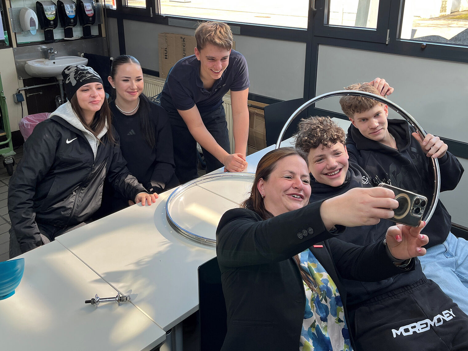 Vizepräsidentin Kathrin Zellner macht ein Selfie mit den Teilnehmern in der Zweirad-Werkstatt.