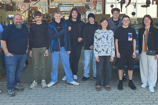 Vizepräsidentin Claudia Geiselhöringer und Bildungszentrumsleiter Matthias Kuhndörfer stehen mit den Schülern vor dem Bildungszentrum.