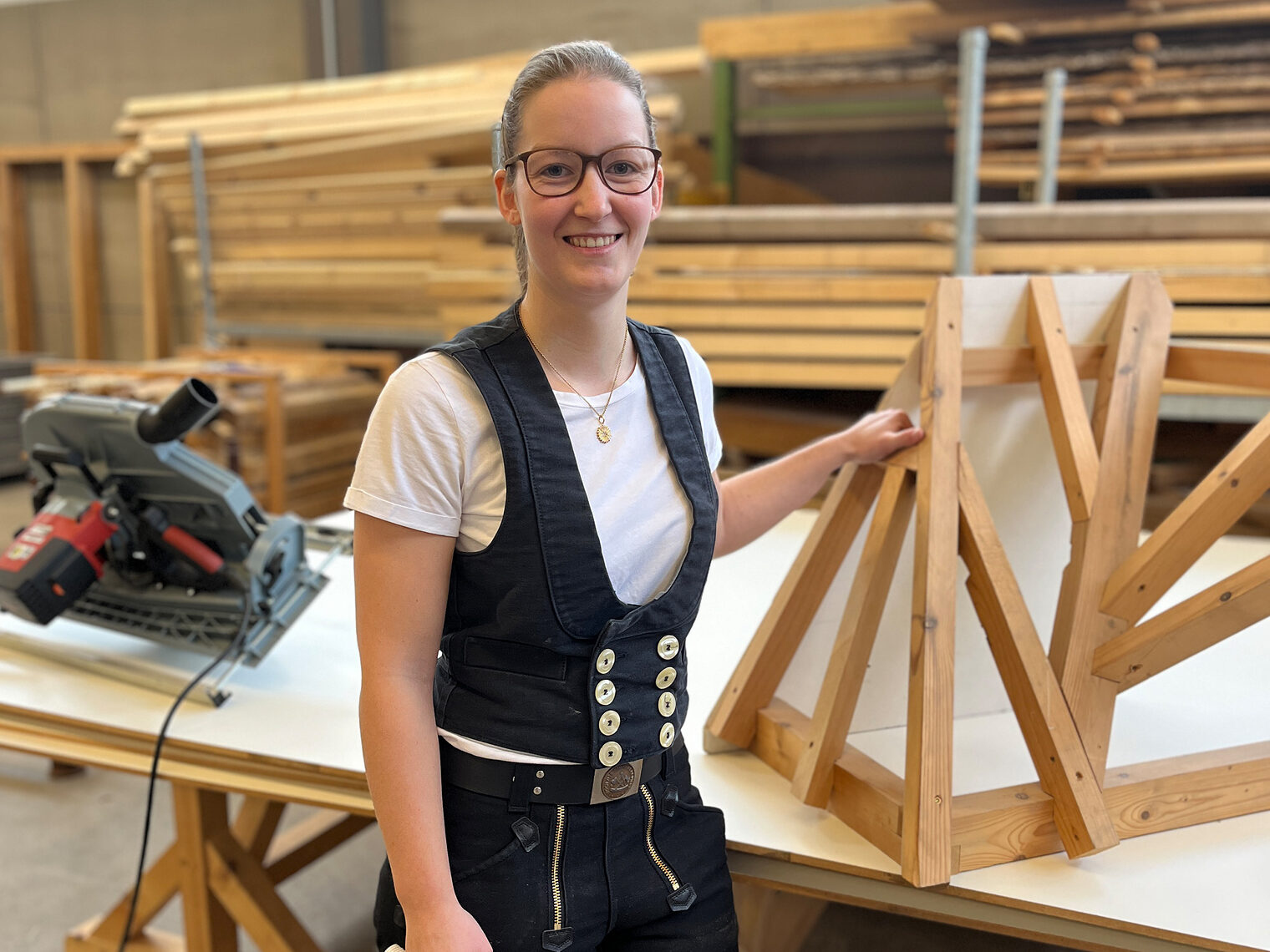 Kerstin Rei schloss als Kursbeste ab. Sie steht stolz neben ihrem Meisterstück und trägt die Zimmermannskluft.