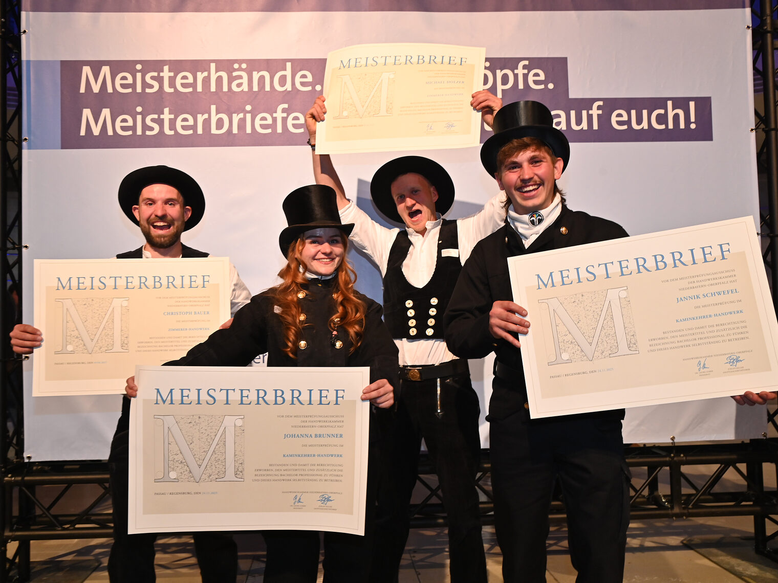 Die Meister freuen sich über ihre lang ersehnten Meisterbriefe. Auf dem Foto Kaminkehrermeister und ein Zimmerermeister. 