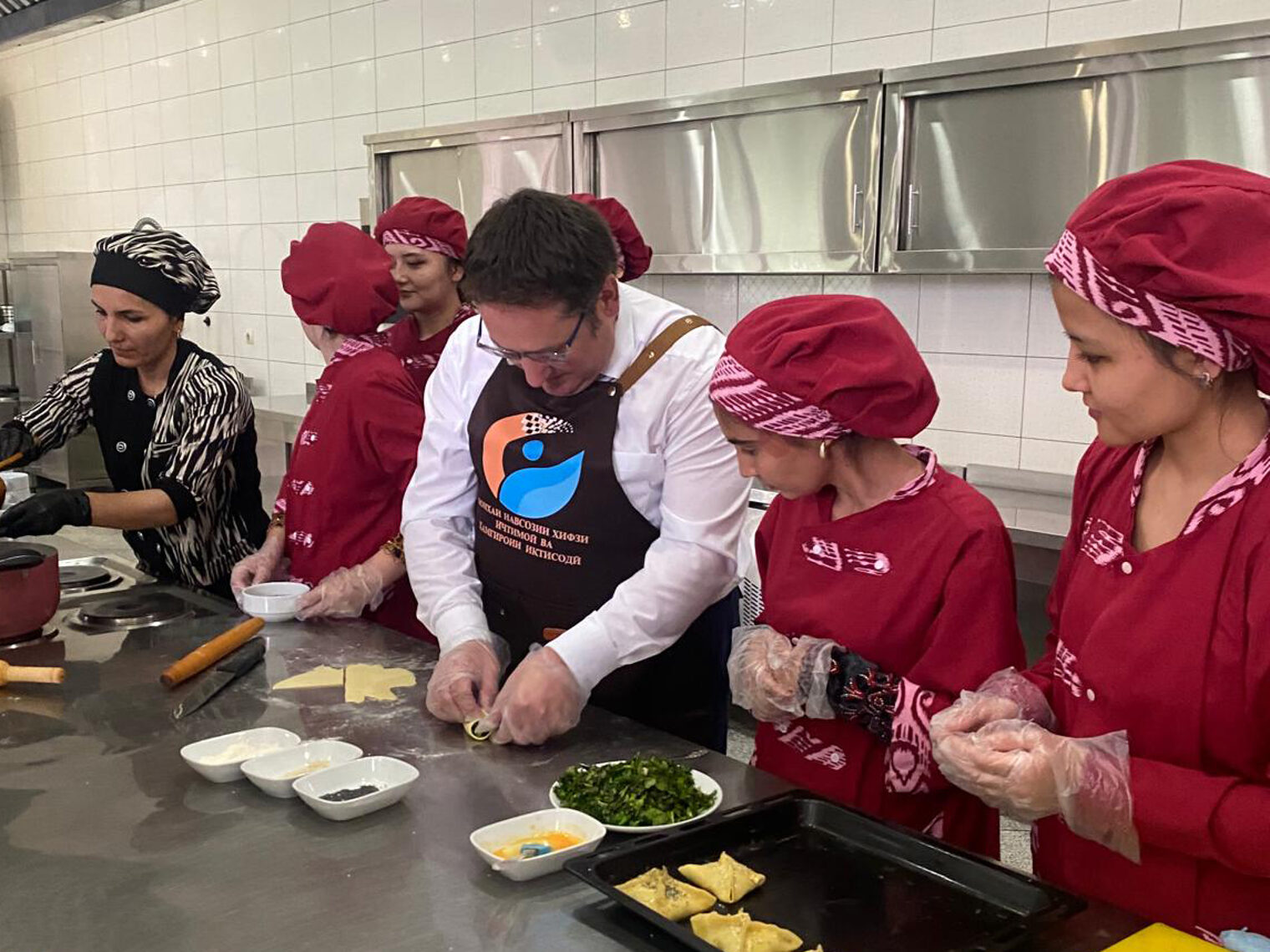 Wirtschaftssekretär Tobias Gotthard inmitten der Schulungseinrichtung. Er darf mit Auszubildenden in der Küche arbeiten.