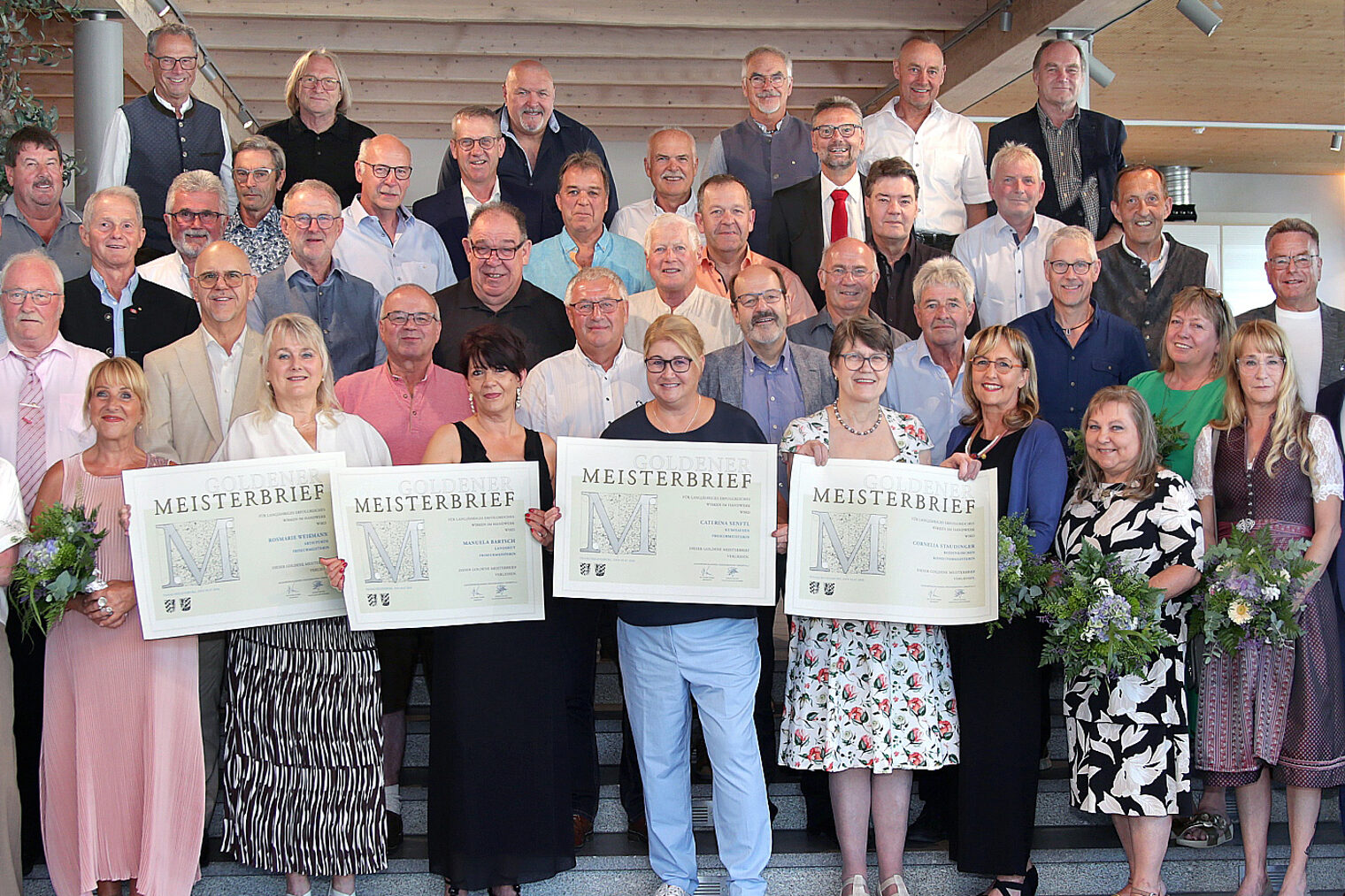 In Ergolding ehrte die Handwerkskammer ihre „Goldenen“ Meisterinnen und Meister. Vier Damen halten die Meisterbriefe in die Höhe.