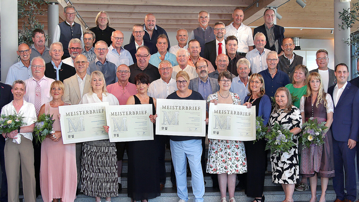 In Ergolding ehrte die Handwerkskammer ihre „Goldenen“ Meisterinnen und Meister. Vier Damen halten die Meisterbriefe in die Höhe.