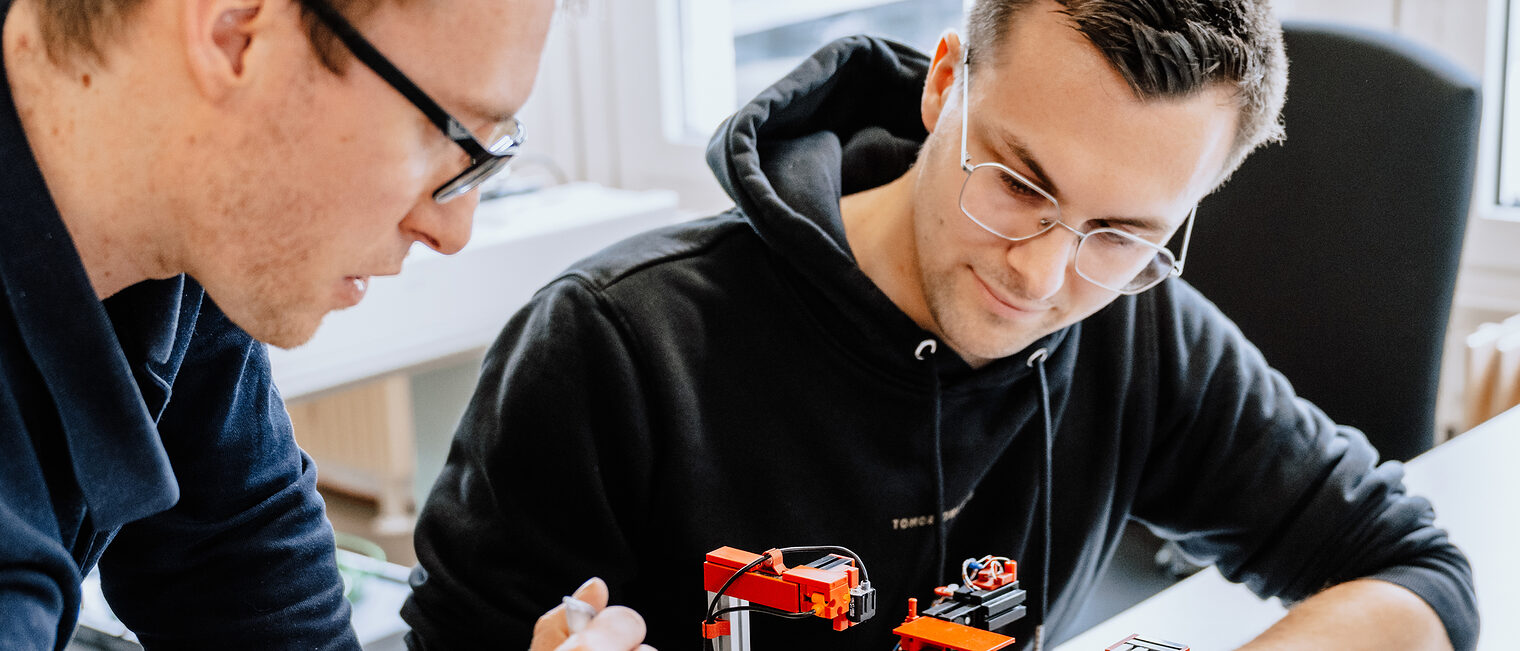 Zwei Meisterschüler tüfteln an einer Elektrokonstellation.