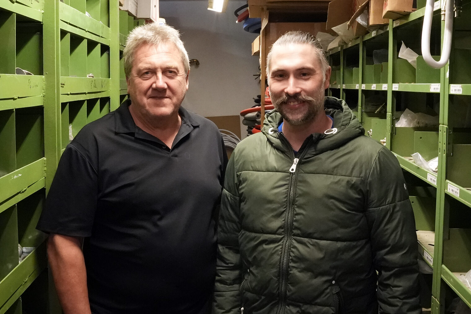Josef Schauer übergab seinen Betrieb an Marcel Anzenberger. Sie stehen gemeinsam in der Werkstatt und posieren für das Bild. 