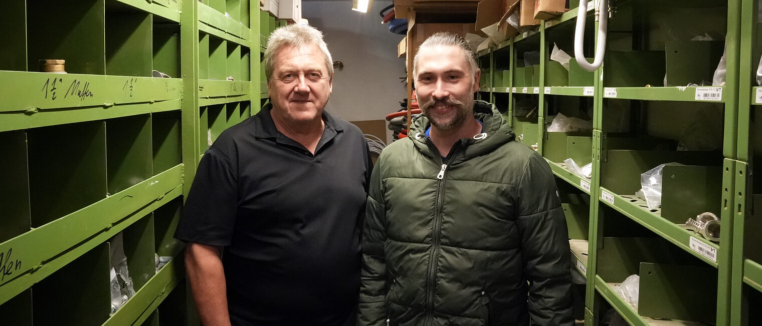 Josef Schauer übergab seinen Betrieb an Marcel Anzenberger. Sie stehen gemeinsam in der Werkstatt und posieren für das Bild. 